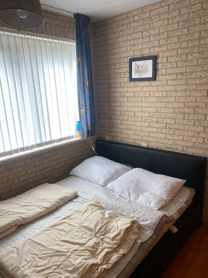 Schlafzimmer mit Doppelbett und weißer Bettwäsche