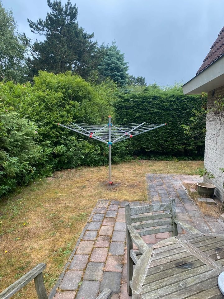 Garten mit Klinkerweg, Gartenmöbeln und hoher Hecke
