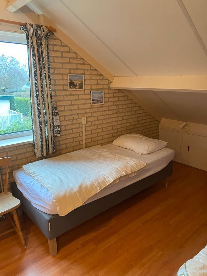 Helles Zimmer unter der Dachschräge mit Einzelbett